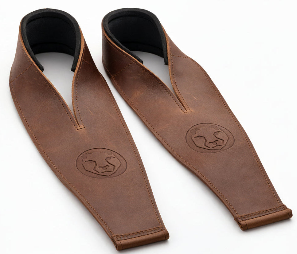 Two brown leather weightlifting straps with black neoprene wrist support on a white background